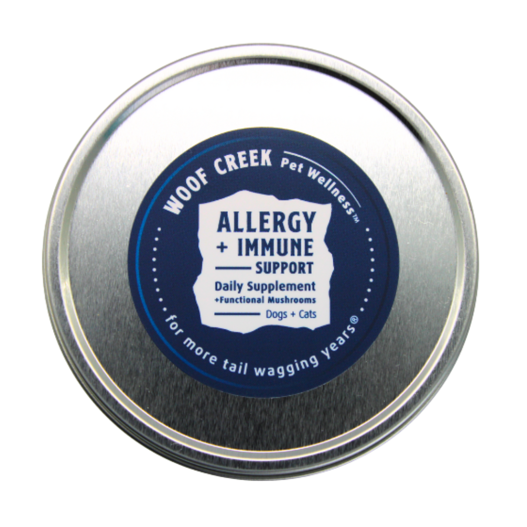 Metal tin labeled 'Woof Creek Pet Wellness' for allergy and immune support for dogs and cats.