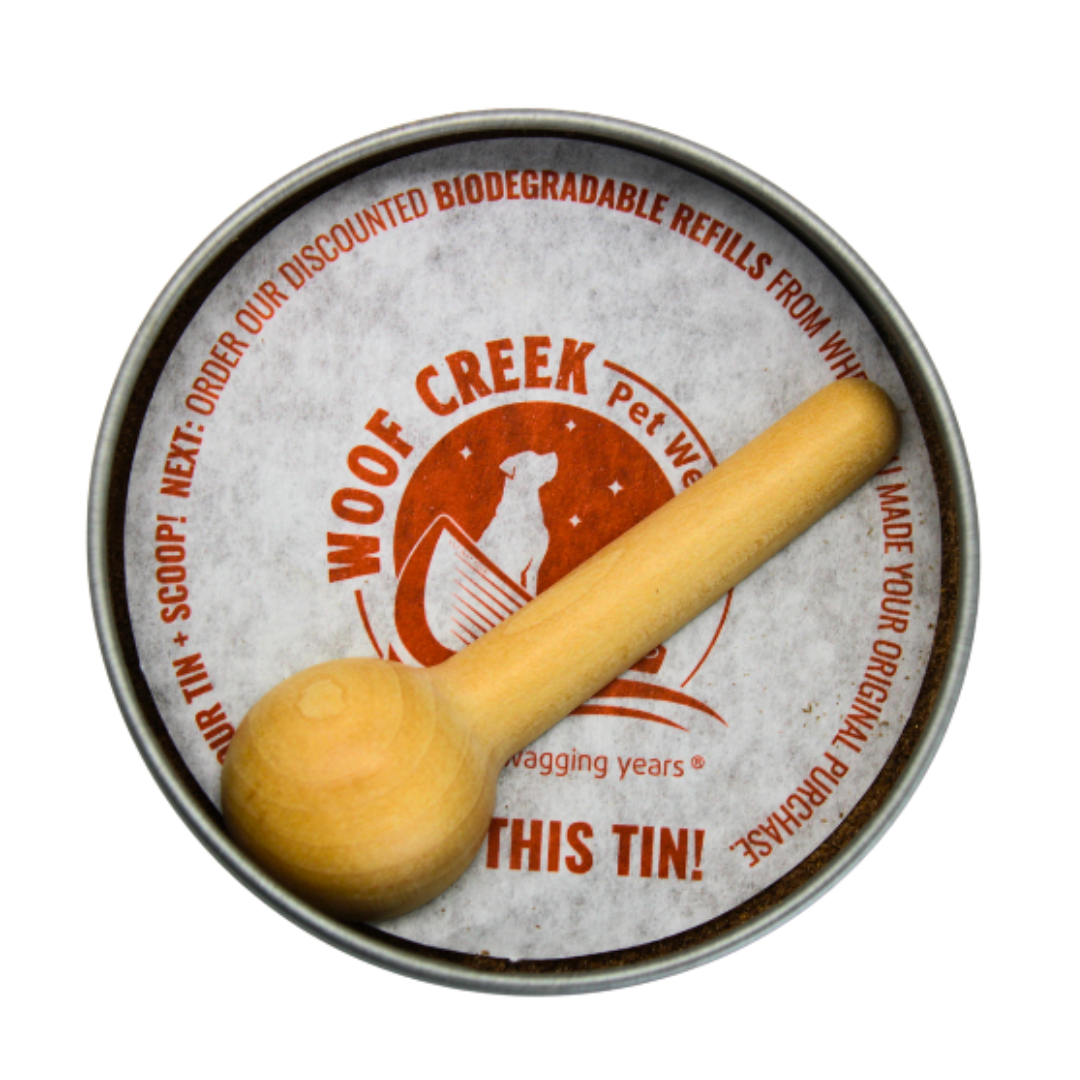 Metal tin with wooden scoop labeled 'Woof Creek Pet' on a white background