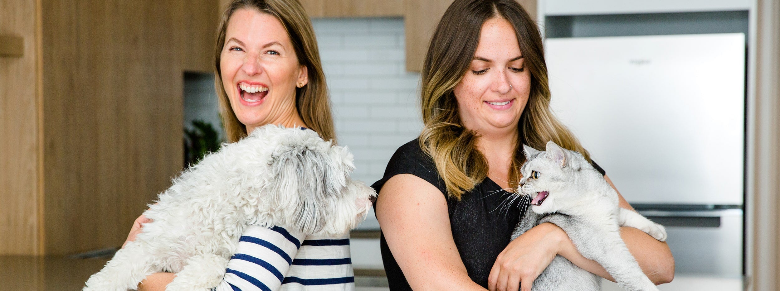 Jen holding her dog and Laura holding her cat