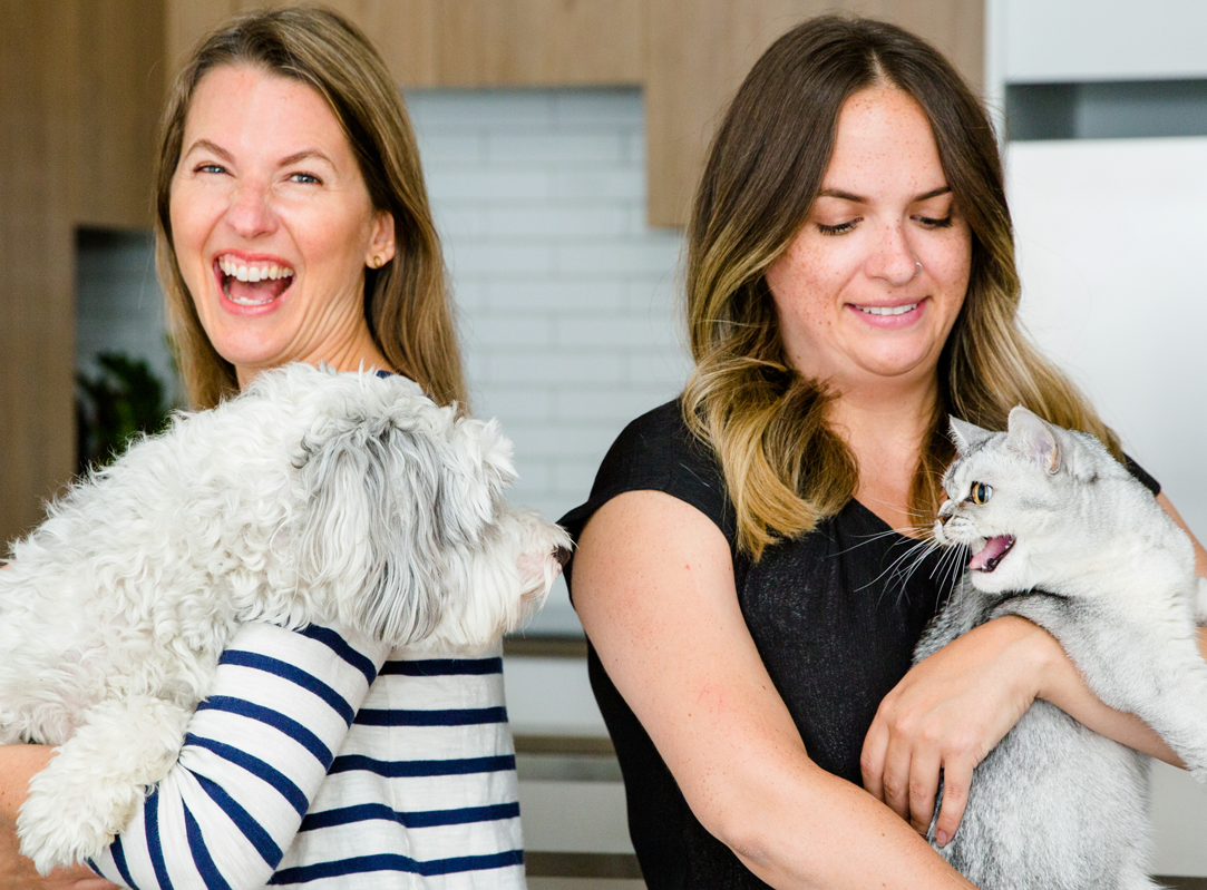 Jen holding her dog and Laura holding her cat