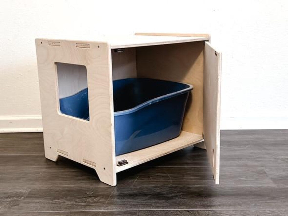 Wooden cat litter box enclosure on a wood floor.