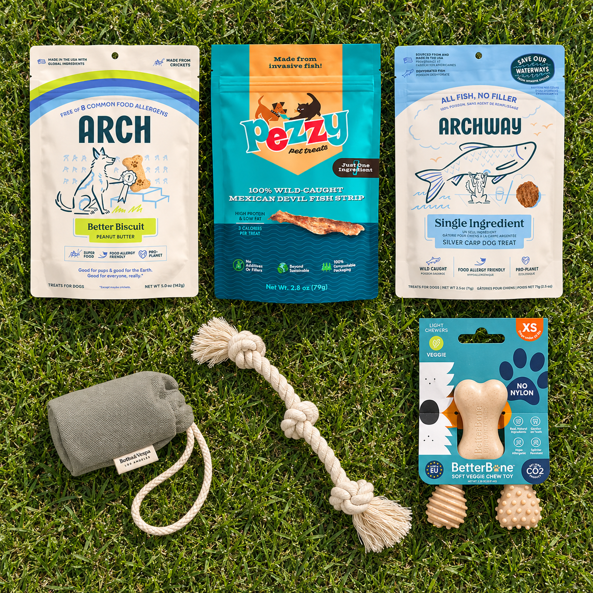 6 puppy treats and toys laying flat on the grass