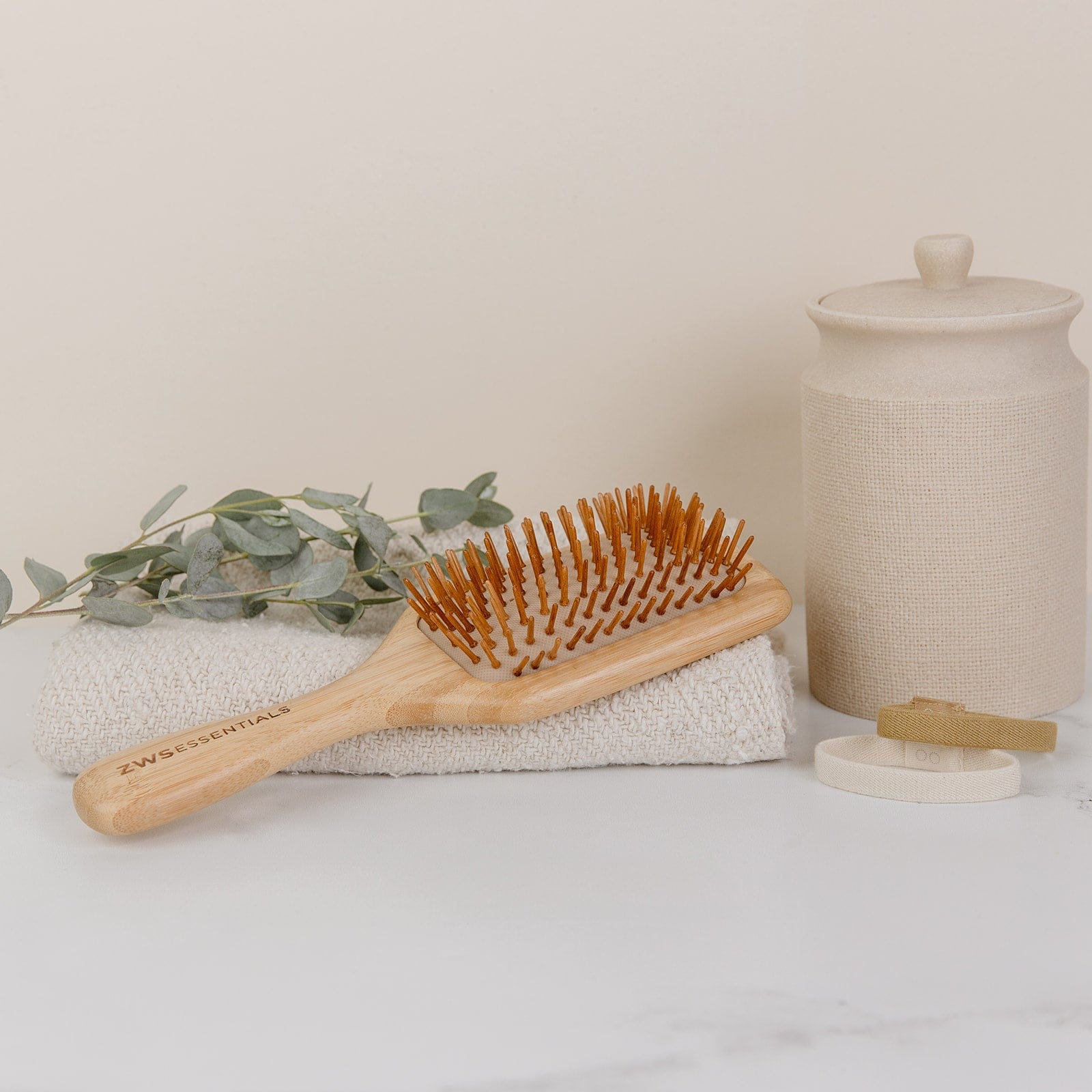 Wooden hairbrush on a textured surface with a neutral background