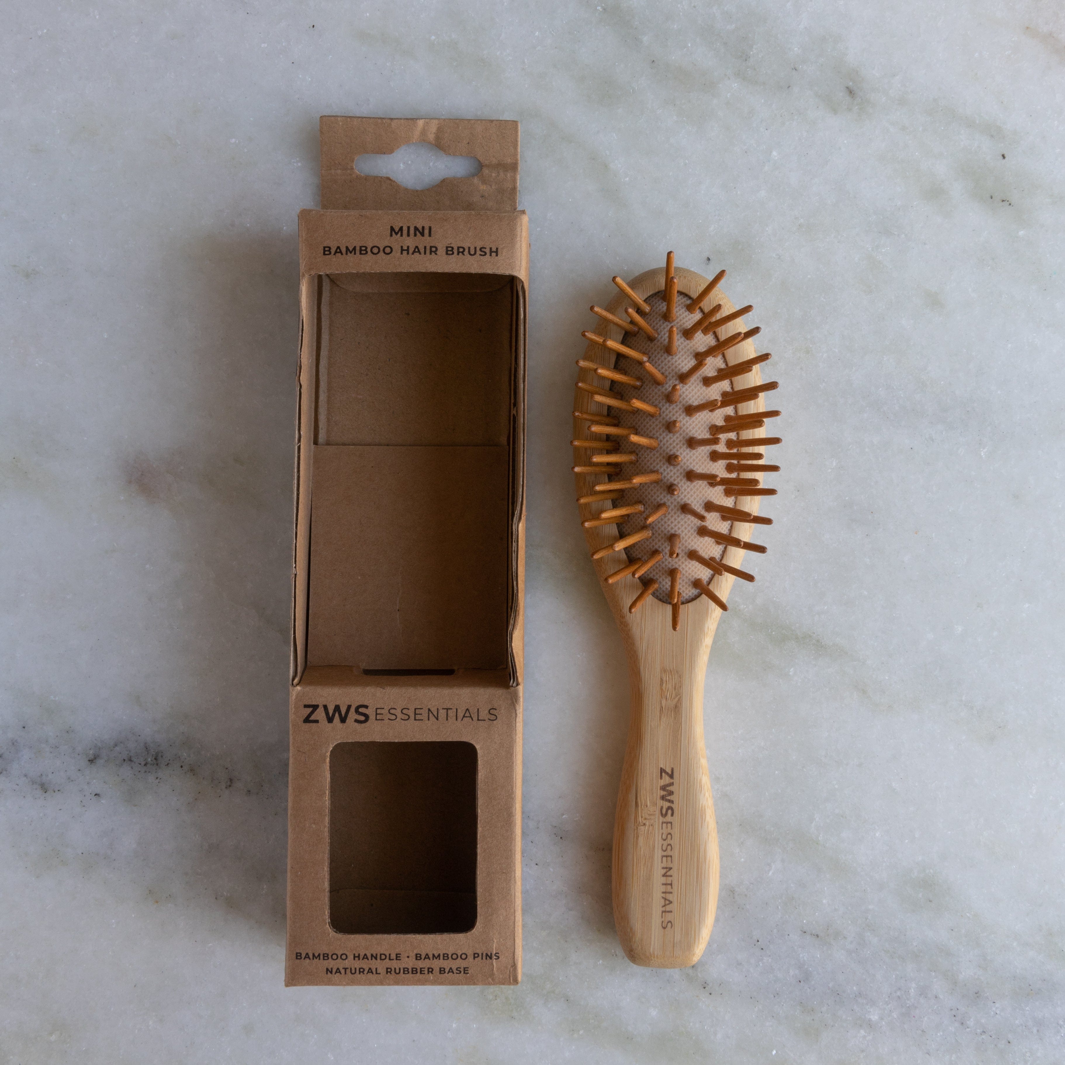Wooden hairbrush with packaging on a marble surface