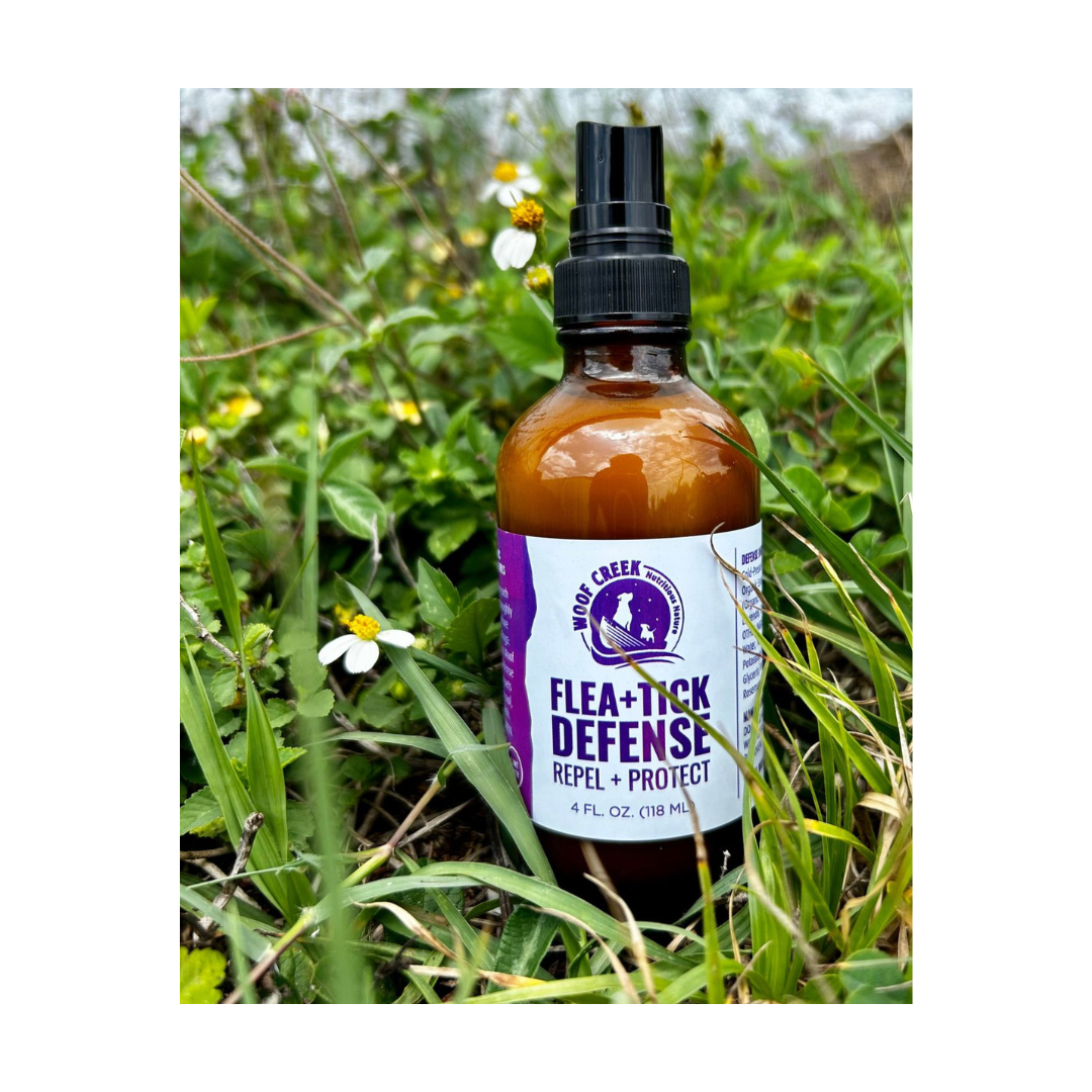 Bottle of Flea & Tick Defense spray in a grassy outdoor setting