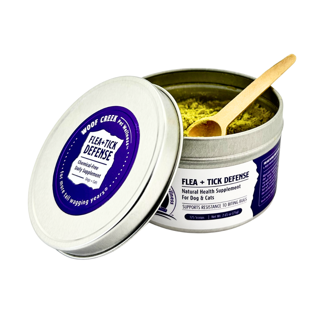Flea and tick defense product in a tin with a wooden scoop on a white background