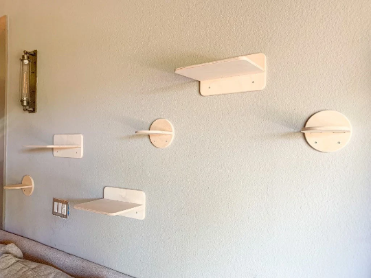 Set of cat wall-mounted shelves in a room with a neutral color scheme.