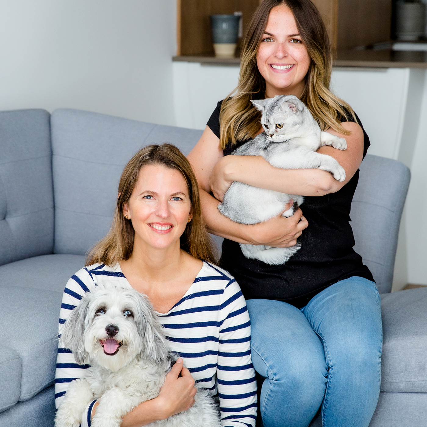 Jen and Laura holding their pet dog and cat