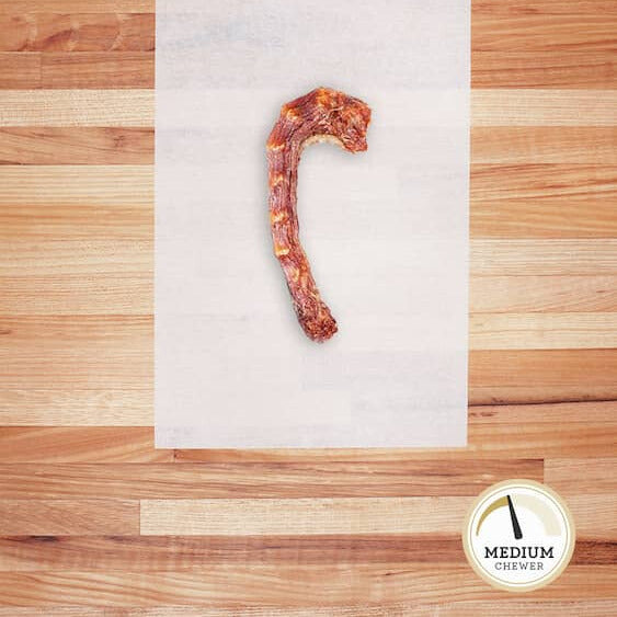 Dehydrated skinless chicken neck on parchment paper.